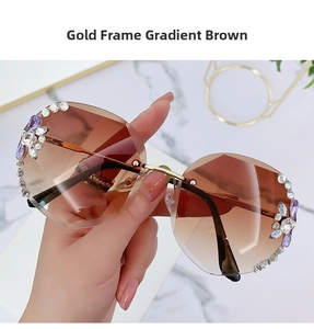 Close-up of gold rimless sunglasses with crystal diamonds and brown gradient lenses