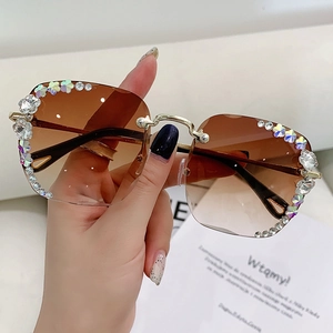 Modische randlose Sonnenbrille mit braunem Verlaufsglas und edlem Kristall-Blumendetail