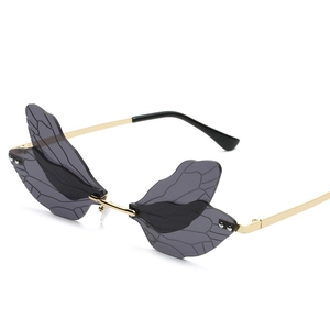 Frameless dragonfly wing sunglasses in translucent smoke gray with golden metal arms