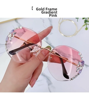 Close-up of gold-rimmed pink gradient rimless sunglasses with rhinestone accents