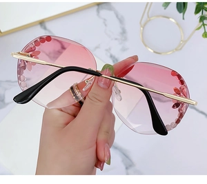 Detail of rimless crystal-cut sunglasses with pink gradient lenses and floral diamond accents