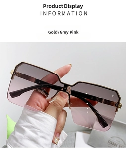 Dettaglio occhiali da sole oversize in metallo dorato con lenti sfumate dal grigio al rosa