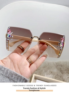 Close-up of rimless gradient sunglasses with luxury rhinestone side decoration