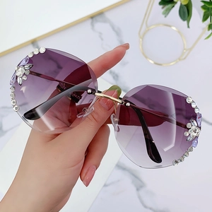 Fashionable rimless sunglasses with purple gradient lenses and sparkling rhinestone accents
