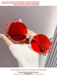 Détail de lunettes de soleil rouges sans monture avec strass et pont doré élégant