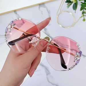 Frameless rimless sunglasses with pink gradient lenses and rhinestone flower accents