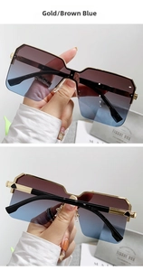 Dettaglio di occhiali da sole oversize senza montatura dorati con lenti sfumate blu