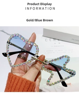 Close-up of heart-shaped rimless sunglasses with gold metal frame and gradient rhinestones