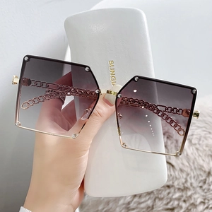 Oversized square sunglasses with purple gradient lenses and gold chain temples