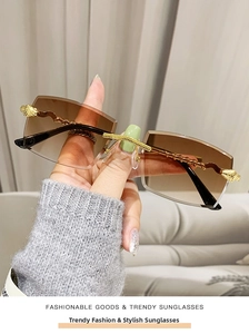 Detail of rimless sunglasses featuring gradient brown lenses and golden twisted metal temples