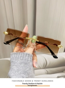 Close-up of golden snake-shaped metal temples on rimless square sunglasses