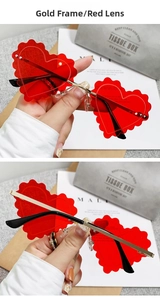 Detail of red heart sunglasses with wavy edges and slender gold metal hinge