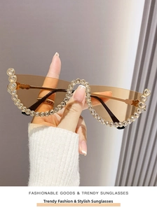 Detailed view of cat-eye sunglasses with crystal-encrusted half-rim and brown lenses