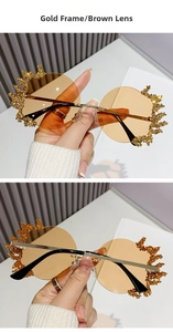 Détails des lunettes de soleil sans monture dorées avec verres bruns et ornements de pierres