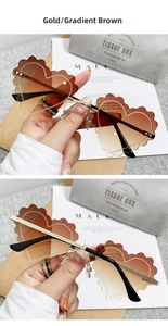 Close-up of heart-shaped rimless sunglasses with wavy cut brown gradient lenses and gold frame