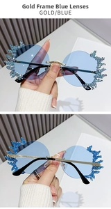 Détail de lunettes de soleil sans monture dorées avec verres bleus et strass bleus