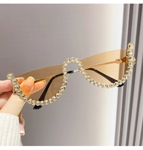 Detail of semi-rimless sunglasses with wavy edges and pavé-set rhinestones in brown tint