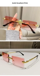 Detail of rimless square sunglasses featuring golden snake-shaped metal temples and pink lenses