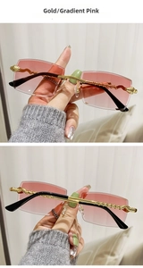 Detail of rimless rectangle sunglasses with gold twisted metal temples and gradient pink lens
