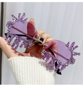 Close-up of purple gradient rimless teardrop sunglasses with crystal-encrusted feather details