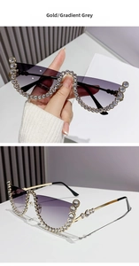 Detail of luxury gold frame sunglasses with gradient grey lenses and crystal trim
