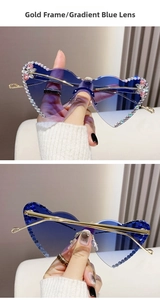 Close-up of rimless heart-shaped sunglasses with blue gradient lenses and rhinestone trim