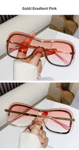 Dettagli di occhiali da sole oversize con montatura in oro e lenti rosa sfumate