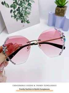 Détail de lunettes de soleil sans monture à dégradé rose avec strass fleuris et branches dorées