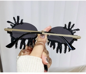 Detailed view of frameless teardrop sunglasses with black lens and crystal rhinestones