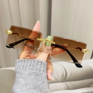 Modern rimless rectangular sunglasses with gold snake spiral temples and brown gradient lenses