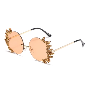 Lunettes de soleil sans monture à verres orange avec cristaux dorés étincelants style flamme