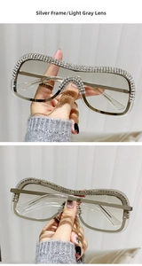 Détail de lunettes en métal argenté avec strass brillants et verres gris clair translucides
