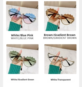Détail de lunettes de soleil sans monture ondulées avec des charnières ornées de strass