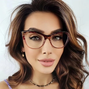 Close-up of tortoise shell cat-eye glasses frame with golden metal hinge details
