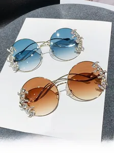 Detail view of rimless rhinestone sunglasses with gradient lenses and gold metal temples