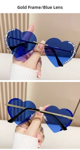 Detailansicht der herzförmigen randlosen Sonnenbrille mit Goldrahmen und blauen Gläsern