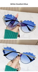 Détail de verres dégradés bleus ondulés avec strass étincelants sur monture en métal doré
