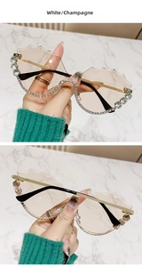 Détail de lunettes de soleil champagne sans monture avec bords vagues et cristaux blancs