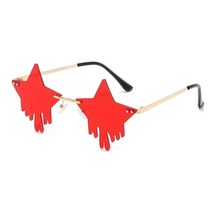 Star-shaped sunglasses with red star lenses and drip effect on a gold frame