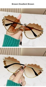 Détail de lunettes de soleil à bords ondulés avec verres dégradés et strass brillants