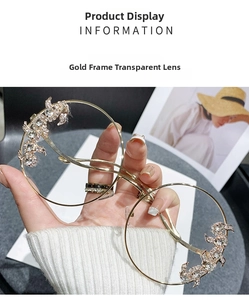 Detailed close-up of rimless gold metal sunglasses with crystal-encrusted dragon decoration