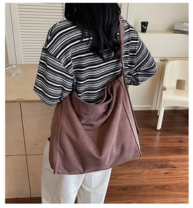 Dettaglio di una borsa tote grande marrone opaca con ampia tracolla in stile minimal