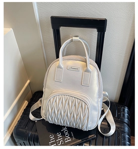 Close-up of white quilted leather and mesh panels on a stylish travel backpack