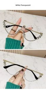 Détail de lunettes de soleil sans monture avec verres festonnés et strass blancs brillants