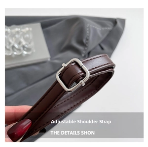 Détail de la bandoulière réglable en cuir marron foncé avec boucle en métal argenté