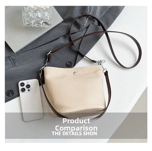 Détail du sac seau tissé beige avec bandoulière en cuir marron et fermoirs argentés