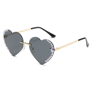 Rahmenlose herzförmige Sonnenbrille mit bunten Strasssteinen und goldenen Metallbügeln