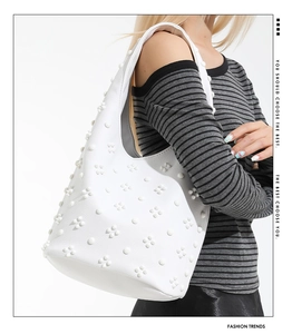 Detailed macro view of white leather hobo bag with unique 3D floral rivet ornaments