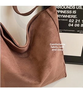 Dettaglio della borsa tote in pelle scamosciata marrone con texture opaca e grande capacità