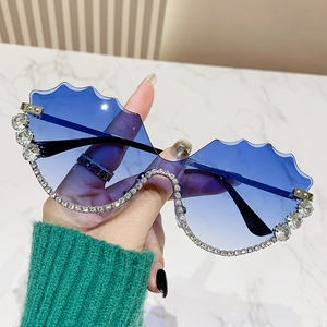 Lunettes de soleil oversize à bords ondulés, verres dégradés bleus et strass brillants
